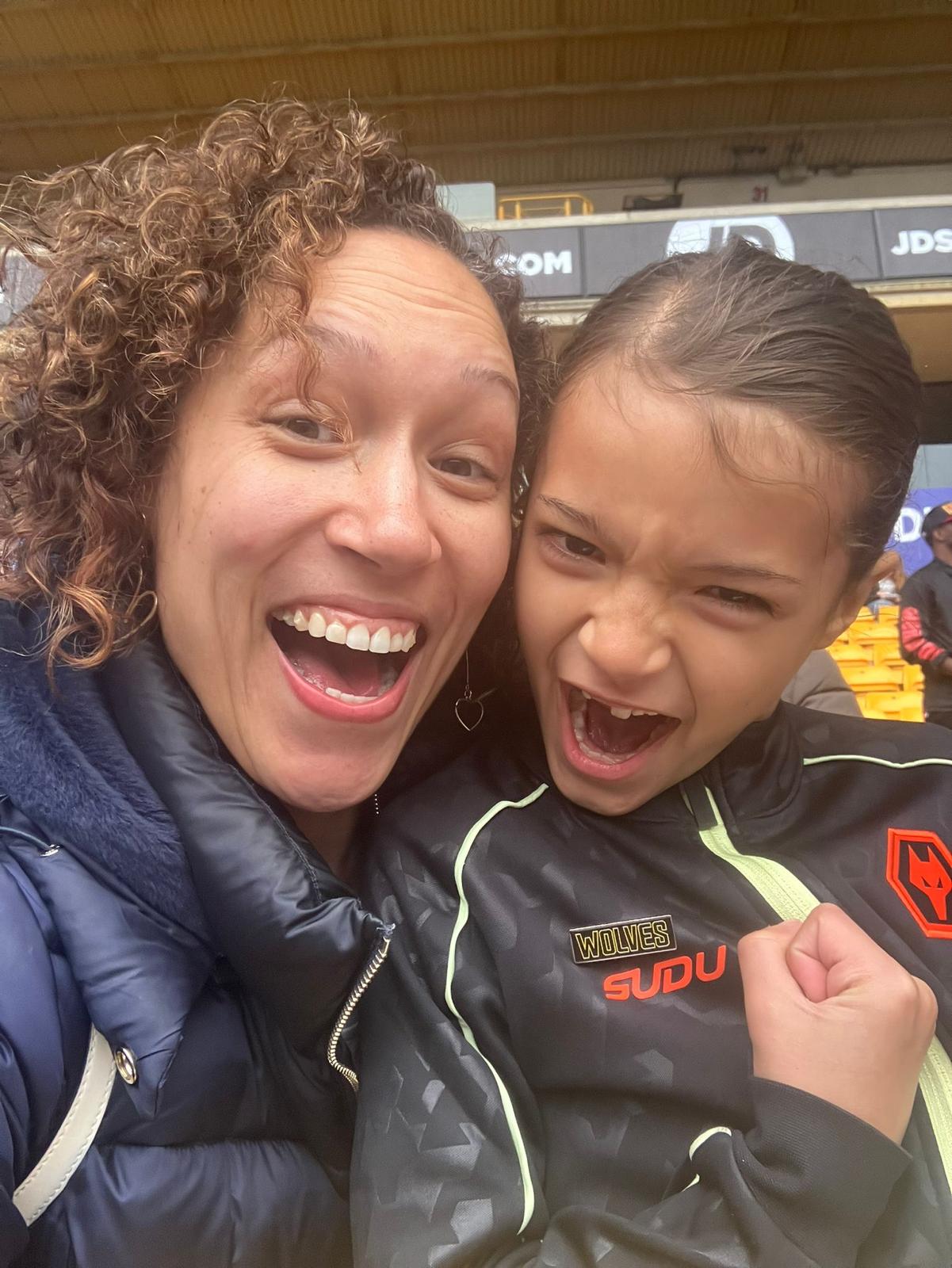Xander celebrating in the stands with a family member at a football stadium