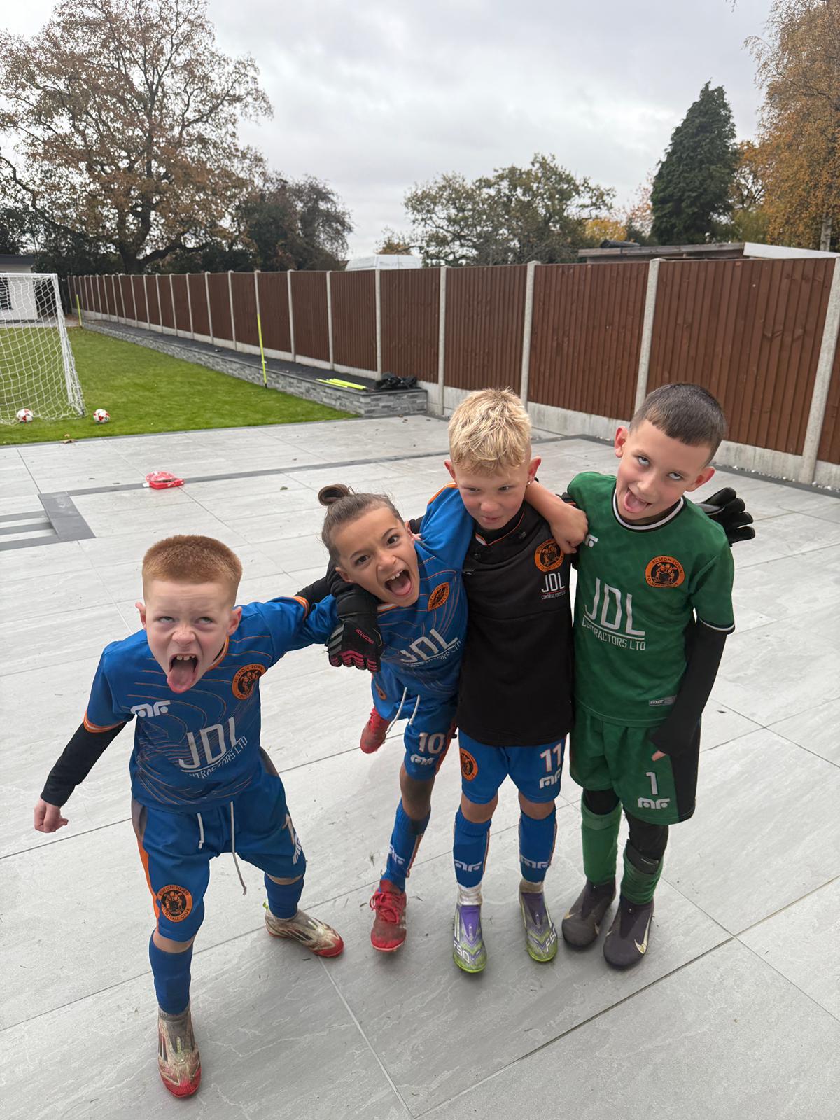 Xander and three team-mates arm-in-arm pulling faces in blue match kits