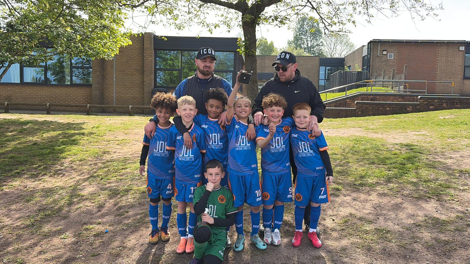 The full squad in blue kits with their two coaches after a game
