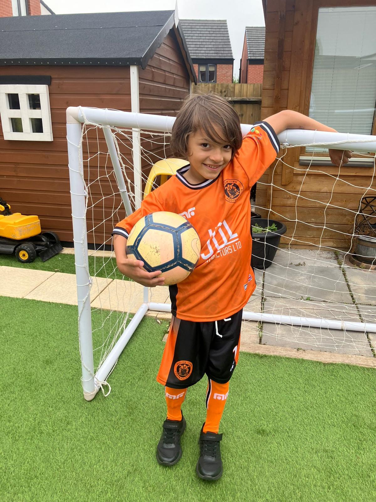 Xander in an orange Bilston Town Warriors kit beside a goal